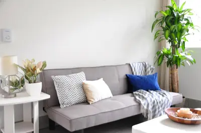 a living room with a gray couch with pillows at Pazifico Villas in Playa Avellana