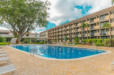 a swimming pool in front of a building at Irazú Hotel & Studios in San José