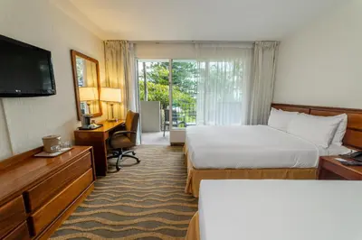 a hotel room with a bed and a television at Irazú Hotel & Studios in San José