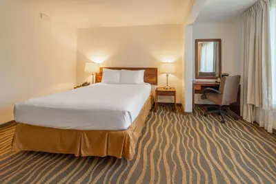 a hotel room with a large bed and a desk at Irazú Hotel & Studios in San José