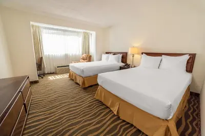 a hotel room with two beds and a window at Irazú Hotel & Studios in San José