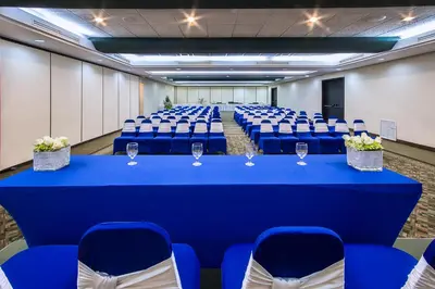 a conference room with a blue table and chairs at Irazú Hotel & Studios in San José