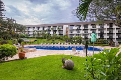 a hotel with a swimming pool in front of a building at Irazú Hotel & Studios in San José