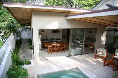 a patio with a table and chairs and a pool at Casa Keshet in Santa Teresa Beach