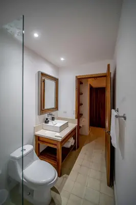 a bathroom with a toilet and a sink and a mirror at Casa Keshet in Santa Teresa Beach