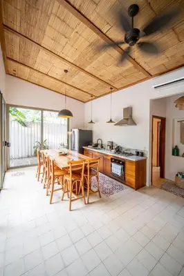 a kitchen with a wooden ceiling and a table and chairs at Casa Keshet in Santa Teresa Beach