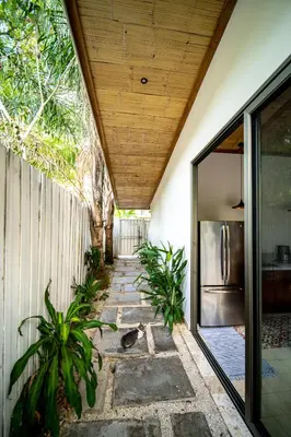 a patio with plants and a stainless steel refrigerator at Casa Keshet in Santa Teresa Beach