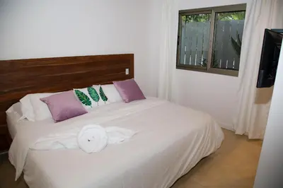 a white bed in a room with a window at Casa Keshet in Santa Teresa Beach