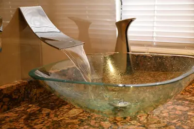 a stream of water pouring into a glass bowl on a counter at 12B Jaco Sol Quadplex in Jacó
