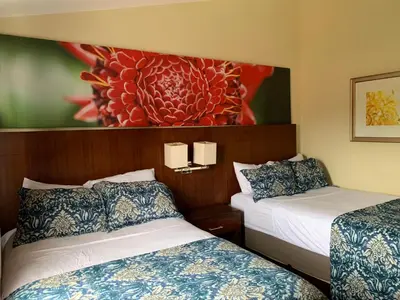 a hotel room with two beds and a painting on the wall at Jaco Sol Quadplex 11A in Jacó