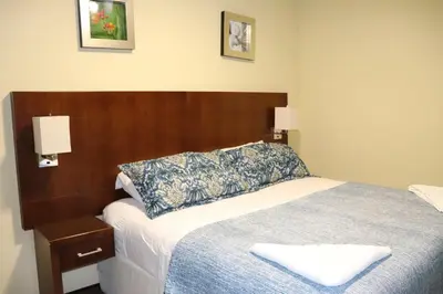 a bedroom with a bed with a wooden headboard at 11B Jaco Sol Quadplex in Jacó