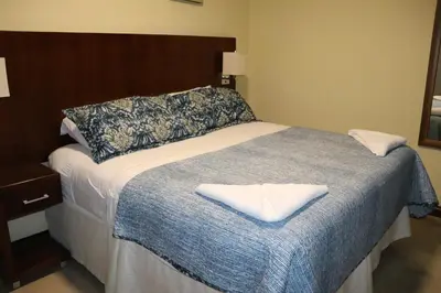 a bedroom with a large bed with a blue blanket at 11B Jaco Sol Quadplex in Jacó
