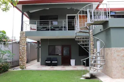 a house with a spiral staircase in front of it at 11B Jaco Sol Quadplex in Jacó