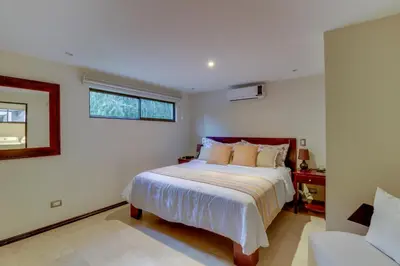 a bedroom with a bed and a window and a couch at The Cove at Playa Ocotal, units 5,6,7 and 8 in Coco