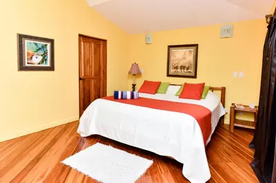 a bedroom with a large bed with red and white sheets at Casa Monos Locos - Portasol Vacation Rentals in Portalón