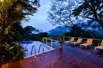 a wooden deck with chairs and a swimming pool at Casa Monos Locos - Portasol Vacation Rentals in Portalón