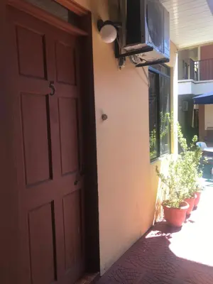 an open door to a house with potted plants at Cabinas Yolymar in Puntarenas