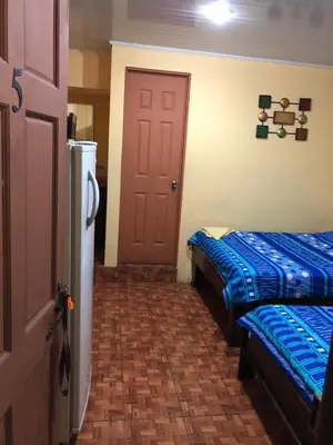 a room with two beds and a door at Cabinas Yolymar in Puntarenas