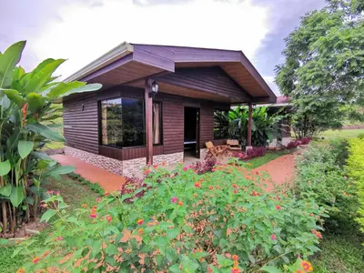 a small house with a garden in front of it at Cabañas Sueños del Arenal in Fortuna