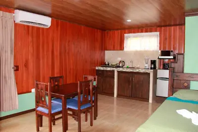 a kitchen with a table and chairs in a room at Cabañas Sueños del Arenal in Fortuna