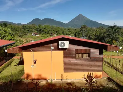 a small house with a clock on the side of it at Cabañas Sueños del Arenal in Fortuna