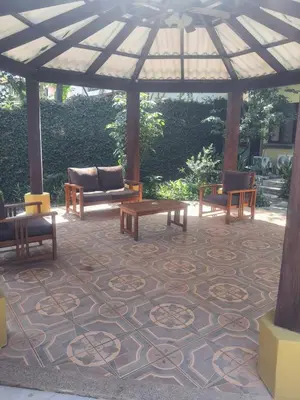a pavilion with couches and tables on a carpet at Casa Sueno Colibri in Tamarindo