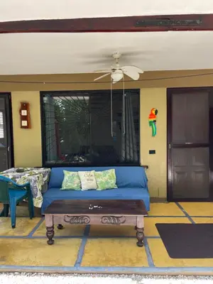 a living room with a blue couch and a window at Casa del Sol in Tamarindo