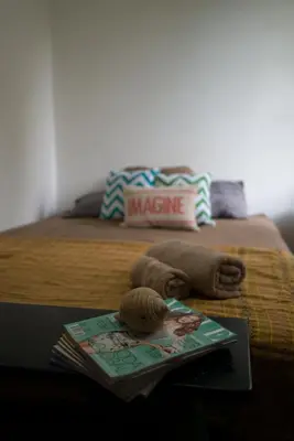 a bed with a table with a magazine on it at Casa del Sol in Tamarindo
