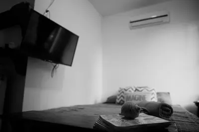 a room with a bed with a tv and a book at Casa del Sol in Tamarindo