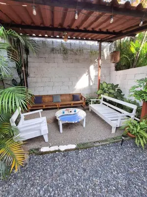 a patio with white benches and a table at Hotel Cortez Azul in Alajuela City