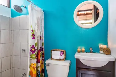 a bathroom with a toilet and a sink and a mirror at ALAJUELA CITY Hotel & Guest House in Alajuela City