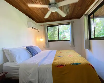 a bedroom with a bed with a ceiling fan at Casa Colores in Montezuma