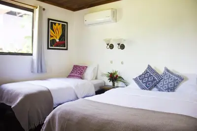 a room with two beds and a window at Casa Colores in Montezuma