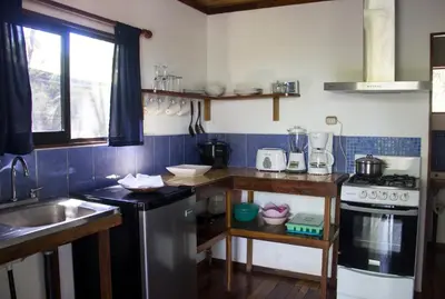 a small kitchen with a sink and a stove at Casa Colores in Montezuma
