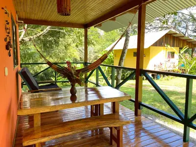 a hammock on the porch of a house at Casa Colores in Montezuma