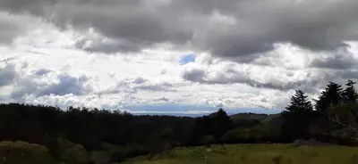 a cloudy sky over a field with trees at Alojamientos Norte y Sur in Monteverde Costa Rica