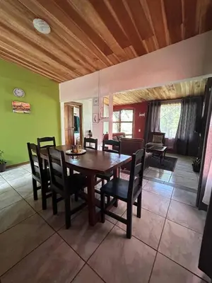 a dining room with a wooden table and chairs at Alojamientos Norte y Sur in Monteverde Costa Rica