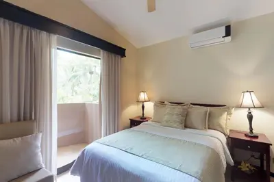 a bedroom with a bed and a large window at The Cove 3/4 in Coco