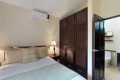 a bedroom with a bed and a bathroom with a toilet at The Cove 3/4 in Coco
