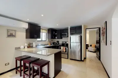 a kitchen with a counter and a refrigerator at The Cove 3/4 in Coco