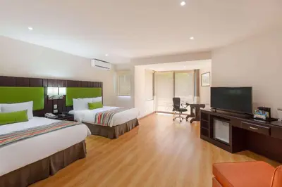a hotel room with two beds and a flat screen tv at Country Inn & Suites by Radisson, San Jose Aeropuerto, Costa Rica in San José