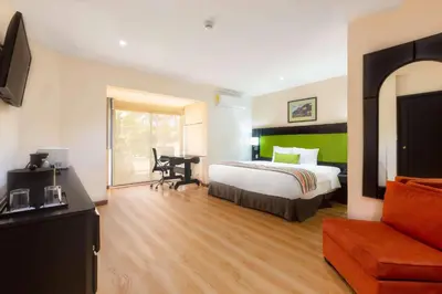 a hotel room with a bed and a desk at Country Inn & Suites by Radisson, San Jose Aeropuerto, Costa Rica in San José