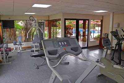 a gym with treadmills and machines in a room at Country Inn & Suites by Radisson, San Jose Aeropuerto, Costa Rica in San José