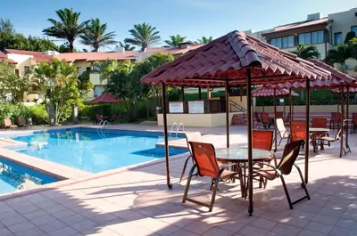 a patio with a table and chairs next to a pool at Country Inn & Suites by Radisson, San Jose Aeropuerto, Costa Rica in San José