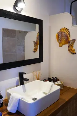 a bathroom with a sink and a fish on the wall at Sueño Río Celeste Boutique B&B in Bijagua