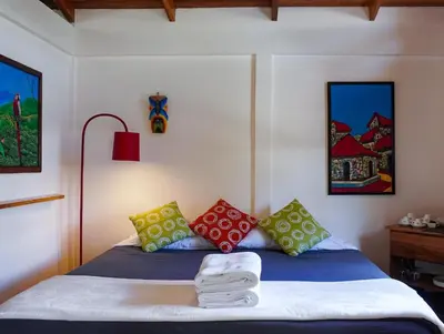 a bedroom with a bed with colorful pillows at Sueño Río Celeste Boutique B&B in Bijagua