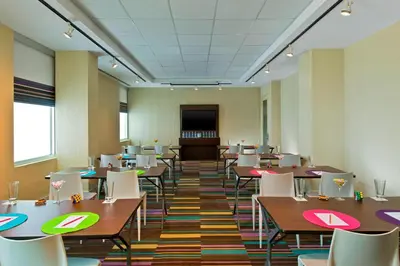 a classroom with tables and chairs and a podium at Aloft San Jose Hotel, Costa Rica in San José