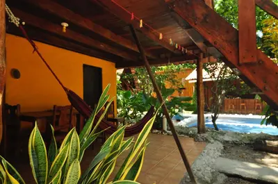 a hammock in the shade of a house at Howler Monkey Hotel in Montezuma
