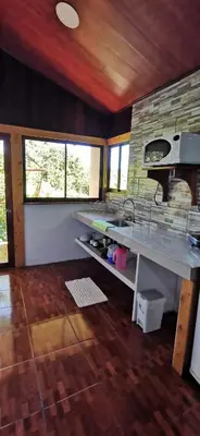 a kitchen with a sink and a stone wall at Mora's Place B&B in Monteverde Costa Rica