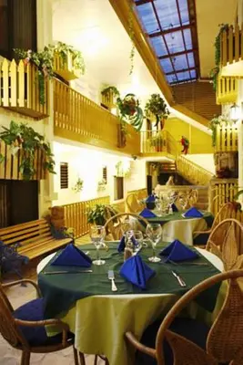 a dining room with a table with blue napkins on it at Adventure Inn in San José